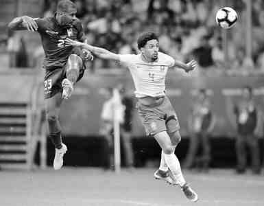 6月18日，巴西队球员马尔基尼奥（右）与委内瑞拉队球员龙东在比赛中拼抢。新华社